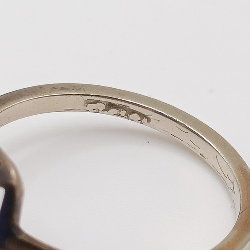 695 - A silver coloured metal and synthetic sapphire ring