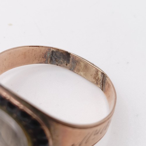 702 - A 19th century yellow coloured metal and red stone memorial ring, inset with a lock of hair, inscrib... 