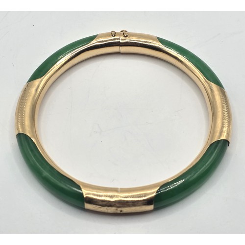 708 - A Chinese 14ct gold and jade bangle, 7 cm diameter