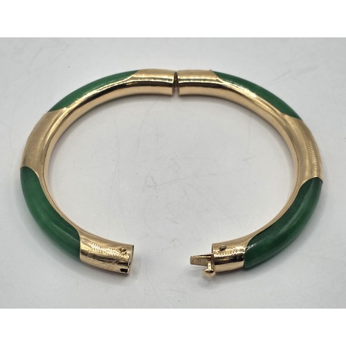 708 - A Chinese 14ct gold and jade bangle, 7 cm diameter