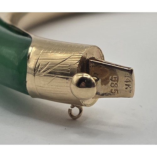 708 - A Chinese 14ct gold and jade bangle, 7 cm diameter