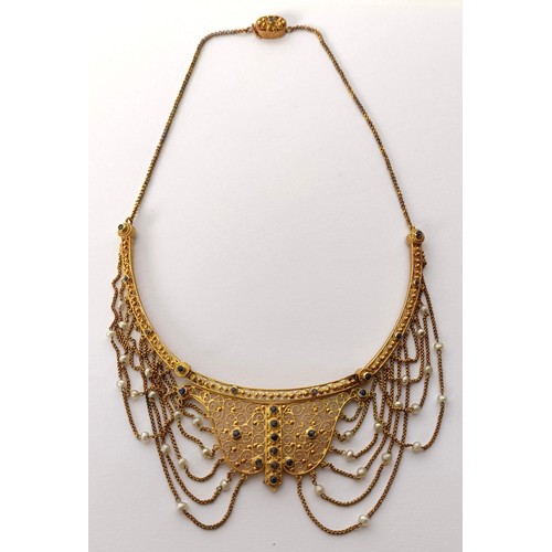 831 - A late 19th/early 20th century Renaissance style yellow metal, sapphire and seed pearl filigree neck... 