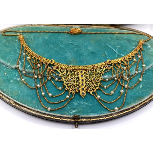 831 - A late 19th/early 20th century Renaissance style yellow metal, sapphire and seed pearl filigree neck... 