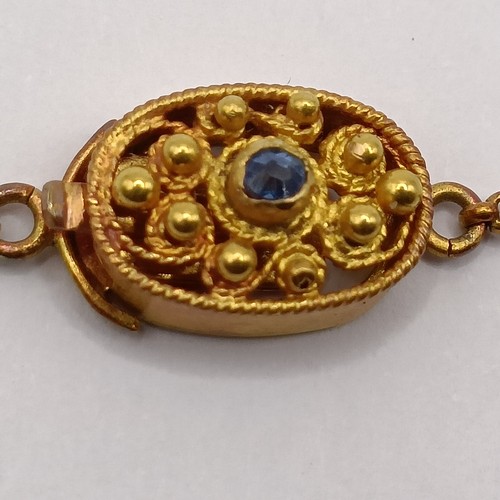 831 - A late 19th/early 20th century Renaissance style yellow metal, sapphire and seed pearl filigree neck... 