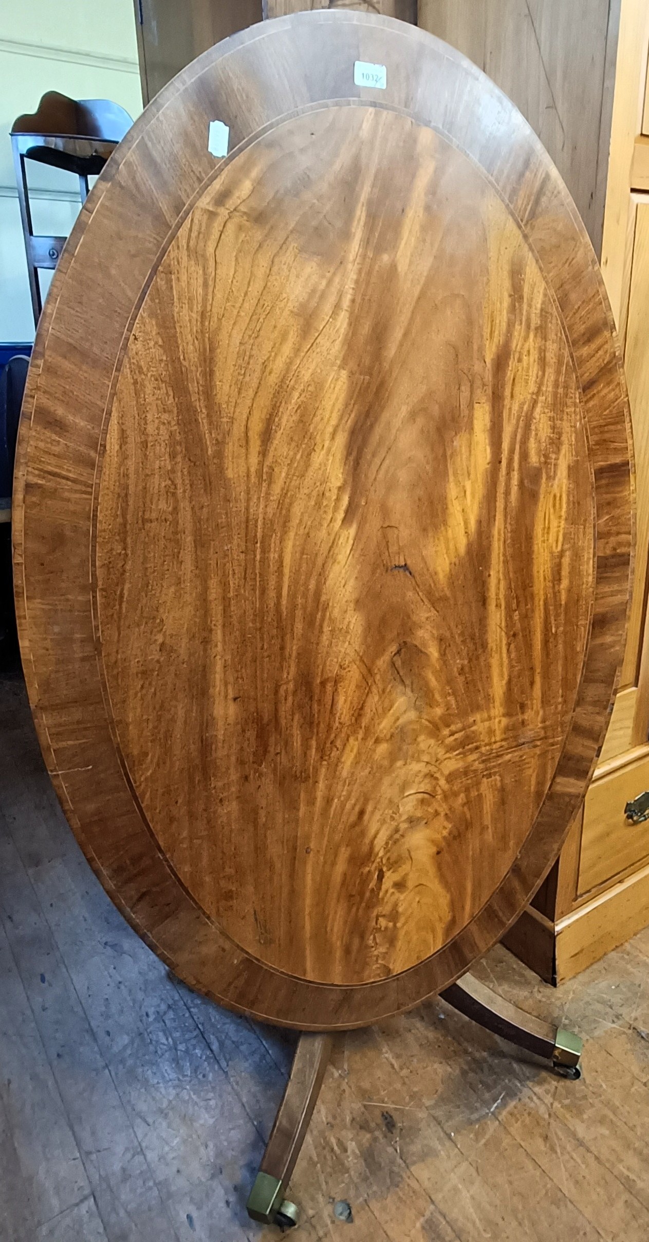 A tilt top oval table, column support to splayed legs, 145 cm wide, a ...