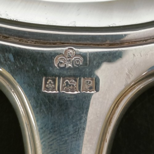 10 - A silver backed hand mirror, a pair of matching brushes and a silver mounted and bakelite lid, 12 cm... 