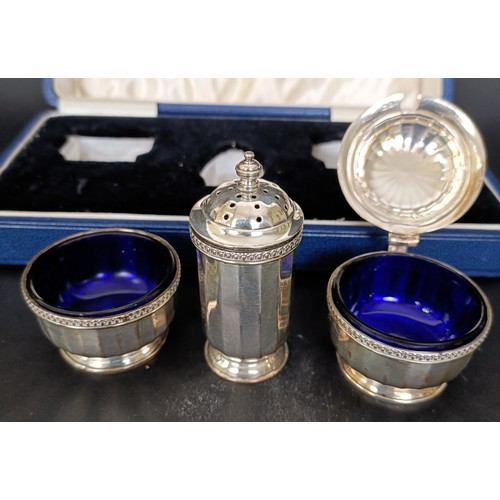13 - A George VI silver three piece cruet, with blue glass liners, 2.7 ozt, cased