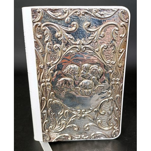 20 - A modern Holy Bible, the front cover with a silver panel embossed cherubs