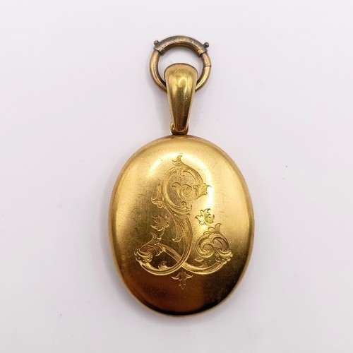 444 - A late 19th century yellow coloured metal oval locket, initialled L