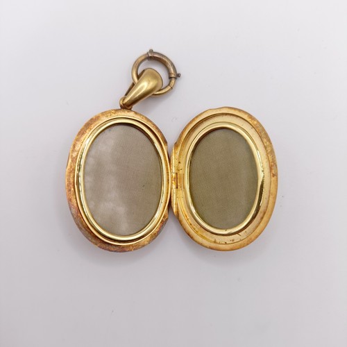 444 - A late 19th century yellow coloured metal oval locket, initialled L