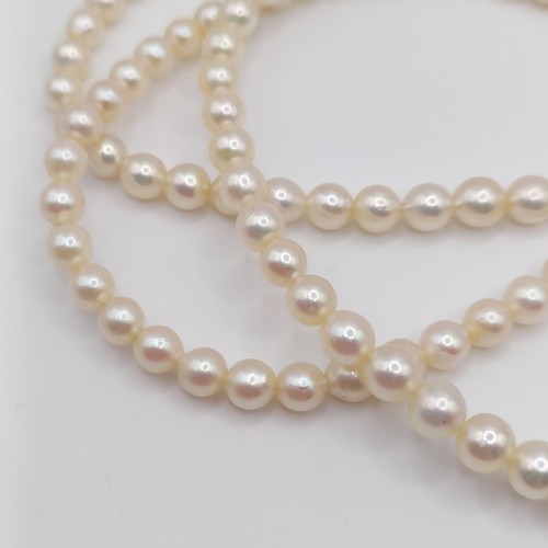 484 - A cultured pearl triple necklace, with a 9ct gold and amethyst clasp