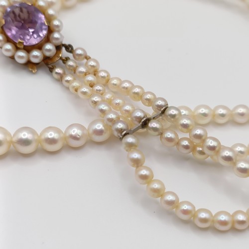 484 - A cultured pearl triple necklace, with a 9ct gold and amethyst clasp