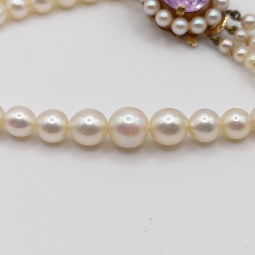484 - A cultured pearl triple necklace, with a 9ct gold and amethyst clasp
