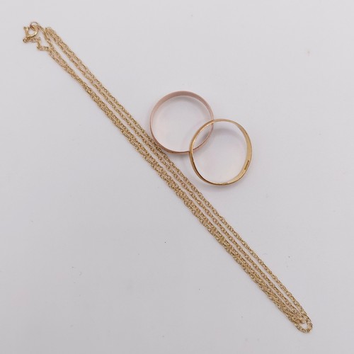 402 - A 22ct gold wedding band, ring size J, 1.4 g, a 9ct gold wedding band, ring size J, 1.3 g, and a yel... 