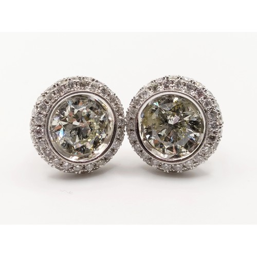 428 - A pair of 18ct white gold and diamond halo earrings, each with a central stone of approx. 1ct
