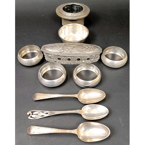 137 - A set of four silver napkin rings, a small silver bowl, three teaspoons, 3.3 ozt, a silver mount, an... 