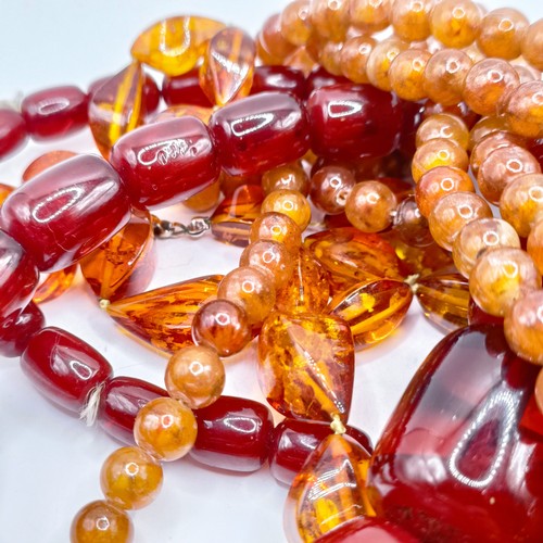 498 - ***Regretfully Withdrawn***A red amber bead necklace and a pair of matching earrings, and two other ... 