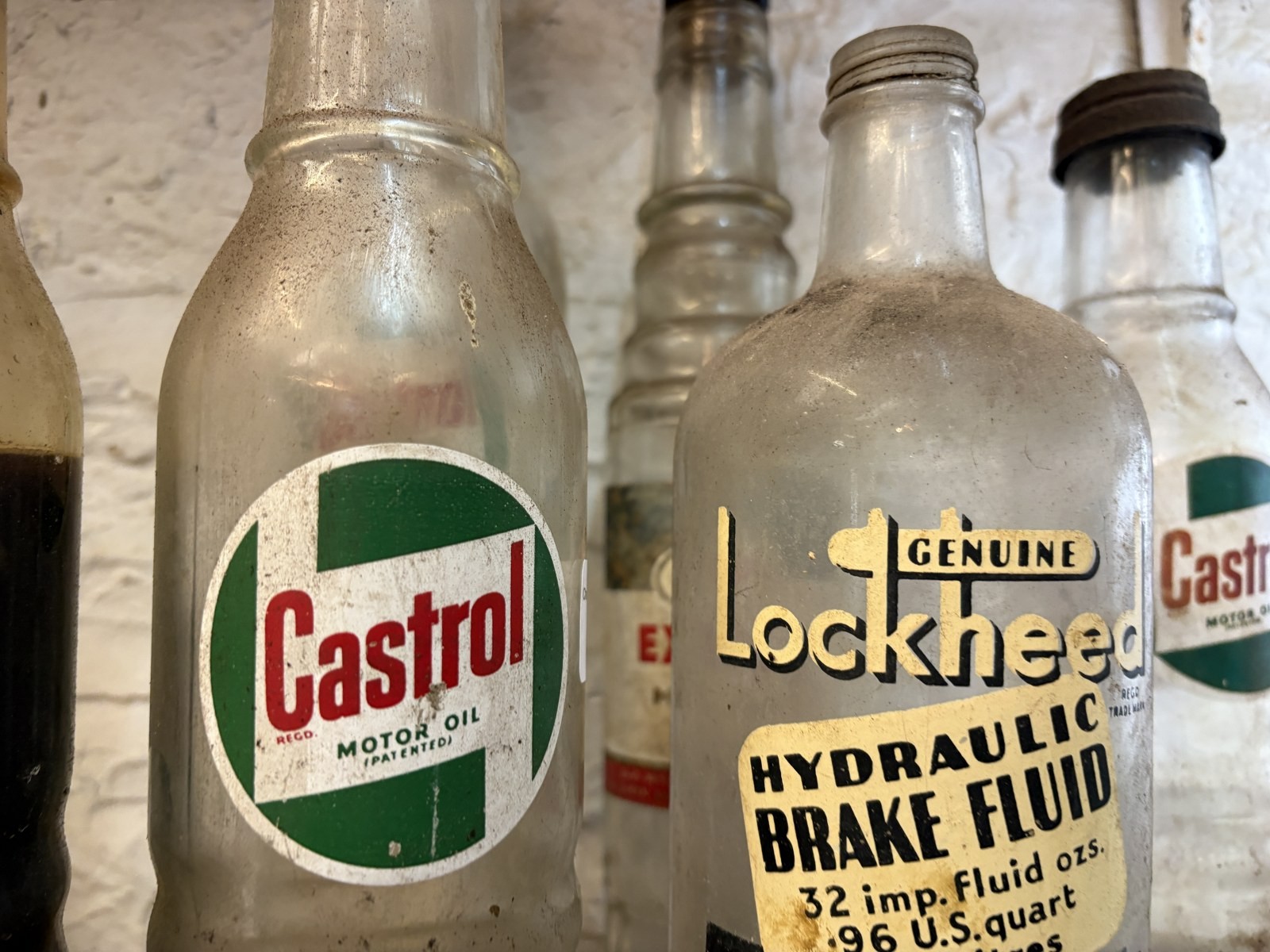 A Lockheed Hydraulic Brake Fluid bottle, and six oil bottles, one with ...