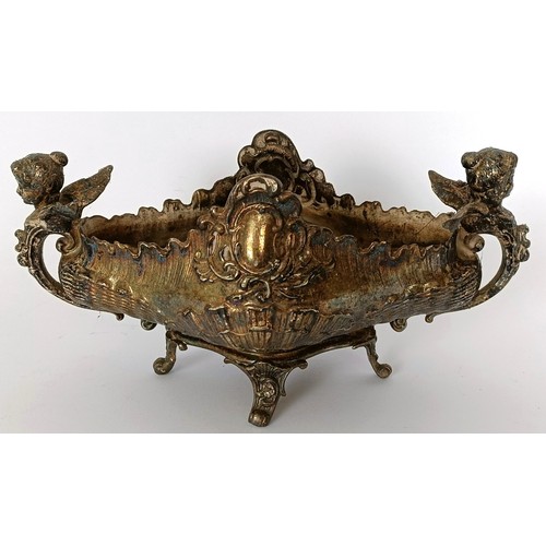 344 - A late 19th/early 20th century silver coloured metal stand, with winged figures, 20 cm wide...
