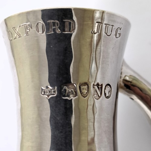 369 - An unusual Victorian hammered silver jug, of slender form, inscribed THE OXFORD JUG, London 1888, 6....