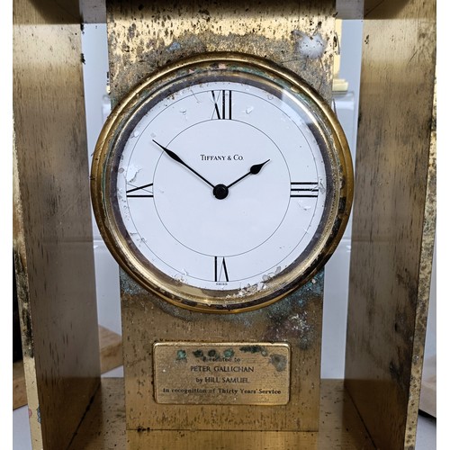 820 - A Tiffany & Co desk timepiece, in a brass case, 23 cm high, a similar clock, three wall sconces,...