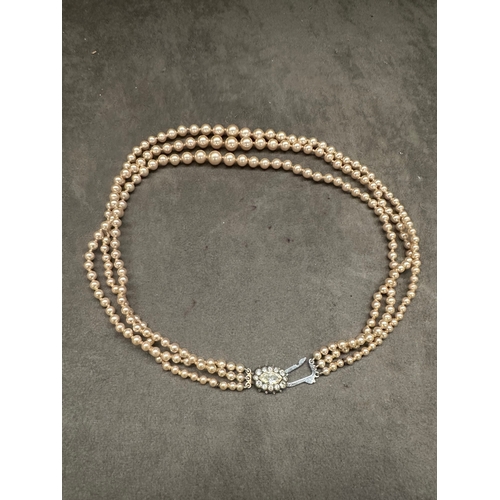 471 - A vintage three-strand necklace, exhibiting a classic style. It is composed of consistent-sized, lig... 