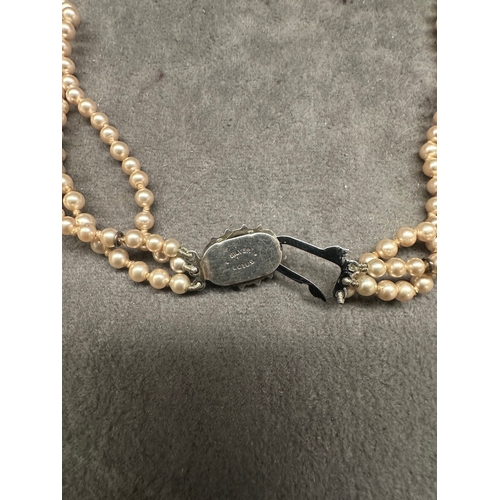 471 - A vintage three-strand necklace, exhibiting a classic style. It is composed of consistent-sized, lig... 