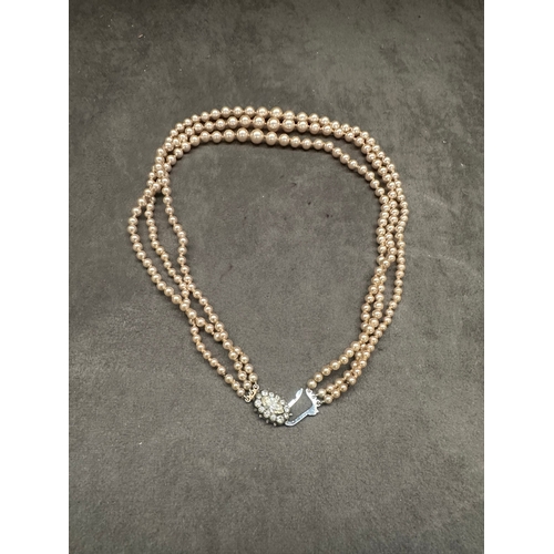 471 - A vintage three-strand necklace, exhibiting a classic style. It is composed of consistent-sized, lig... 