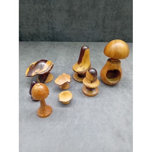 22 - A collection of eight turned wooden objects, primarily crafted in various mushroom forms, exhibiting... 