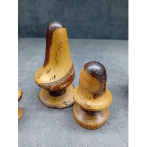 22 - A collection of eight turned wooden objects, primarily crafted in various mushroom forms, exhibiting... 