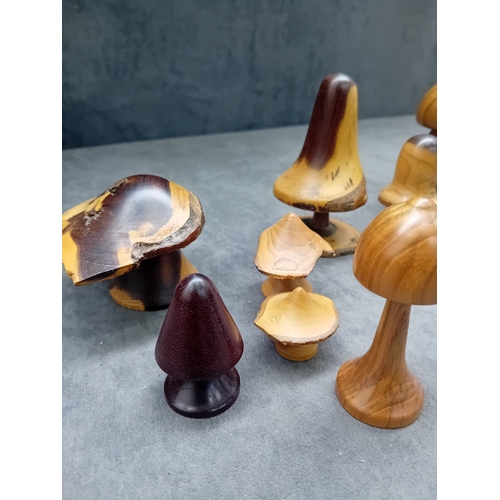22 - A collection of eight turned wooden objects, primarily crafted in various mushroom forms, exhibiting... 