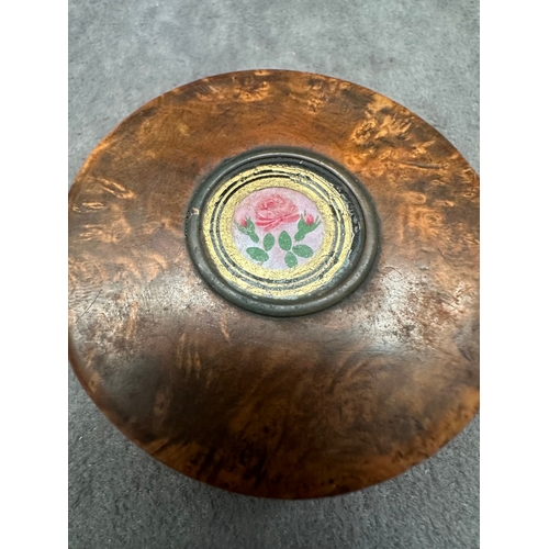 26 - A small, round burl wood box featuring a lift-off lid. The lid is adorned with a central circular me... 