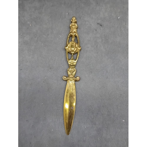 464 - A Malaysian silver Kris letter opener, exhibiting a wavy, damascened iron or steel blade, an ornate ... 