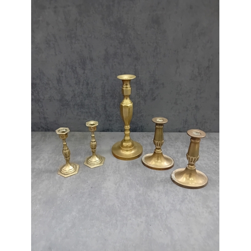 482 - This lot comprises five brass or brass-alloy candleholders/candlesticks, presenting a variety of sty... 