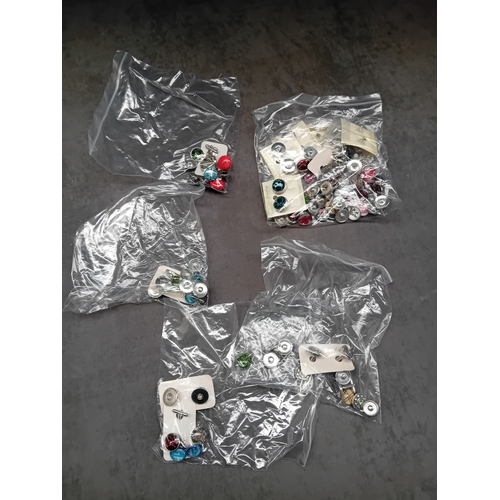 521 - A collection of five separate, sealed clear plastic bags containing assorted interchangeable snap bu... 