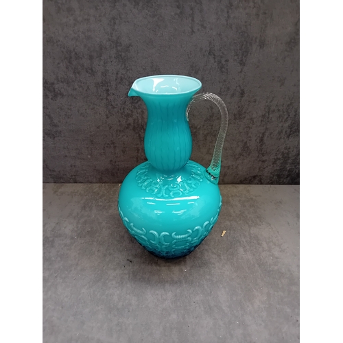 575 - A 20th Century Italian blue glass jug. This opaline glass vessel presents in a vibrant, opaque turqu... 