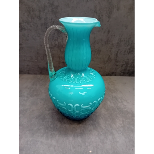 575 - A 20th Century Italian blue glass jug. This opaline glass vessel presents in a vibrant, opaque turqu... 