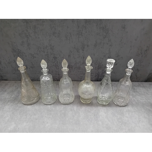 583 - A collection of six clear glass decanters, each accompanied by a decorative stopper. The vessels exh... 