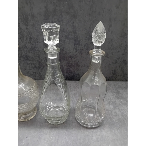 583 - A collection of six clear glass decanters, each accompanied by a decorative stopper. The vessels exh... 