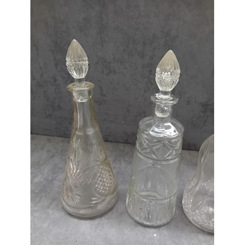 583 - A collection of six clear glass decanters, each accompanied by a decorative stopper. The vessels exh... 