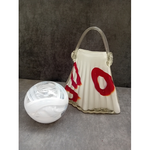 584 - The first object is a stylized, fluted glass vessel, resembling a handbag or purse. It is crafted fr... 