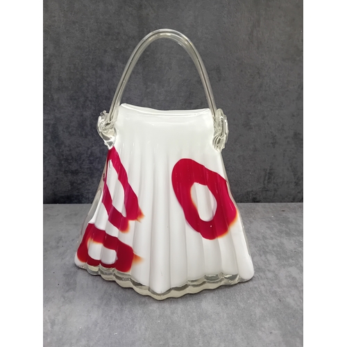 584 - The first object is a stylized, fluted glass vessel, resembling a handbag or purse. It is crafted fr... 