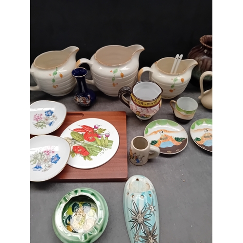 609 - The lot consists of 23 items of mixed ceramic, porcelain, and stoneware, including vases, pitchers, ... 