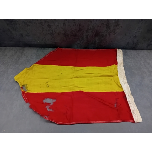 65 - A Spanish flag, featuring three horizontal stripes: red at the top, a wider yellow in the middle, an... 