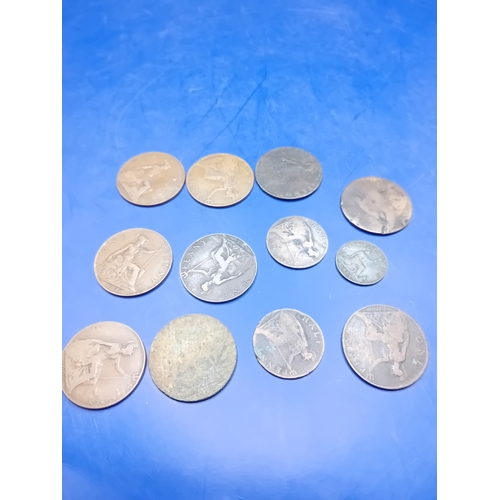 661 - A collection of 12 heavily circulated British base metal coins, primarily copper and bronze, dating ... 