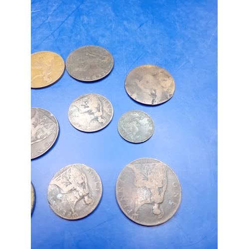 661 - A collection of 12 heavily circulated British base metal coins, primarily copper and bronze, dating ... 