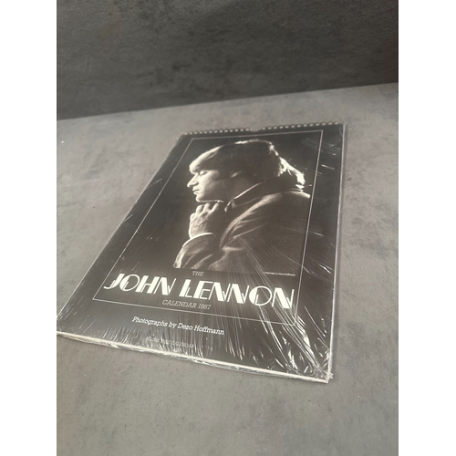 35 - A vintage wall calendar titled The John Lennon Calendar 1987 featuring black and white photography b... 