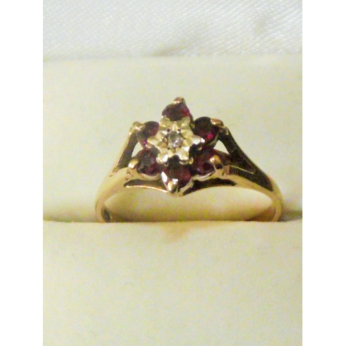 74 - Ladies 9ct gold ring set with small central diamond surrounded with garnets 2.1g approx size M