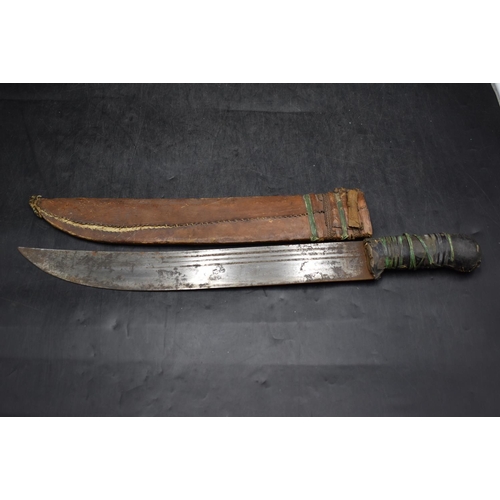 83 - Vintage African short sword with curved single edge blade and a decorated leather scabbard. 55cm lon... 