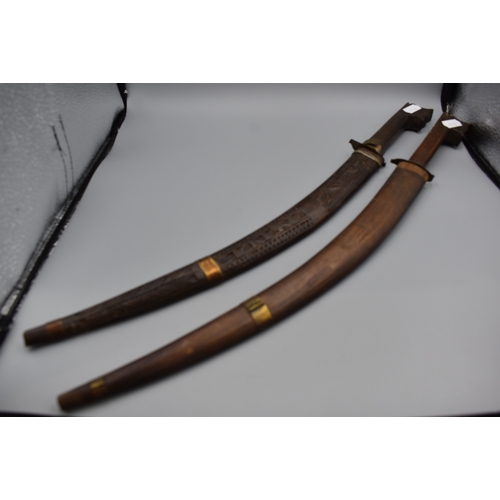 113 - Pair of African Nimcha Daggers 43cm long, both in Carved Wood Scabbards